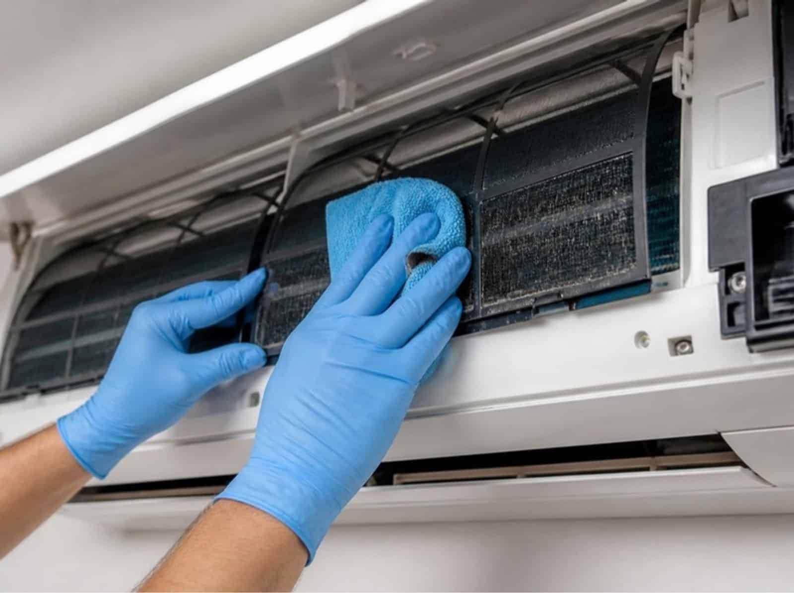 Technician cleaning the filter of a split system air conditioner